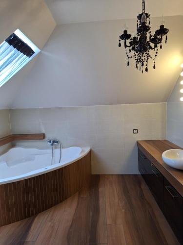 a bathroom with a large tub and a sink at Apartament Perła Pienin in Dębno