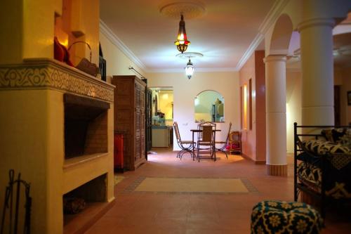 a living room with a fireplace and a dining room at Villa Zazate in Ouarzazate
