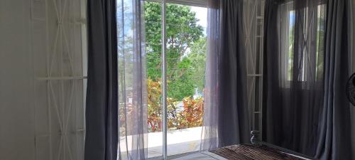 a bedroom with a window with a view of a yard at By The Bay Oracabessa Queen Bedroom Suite in Oracabessa