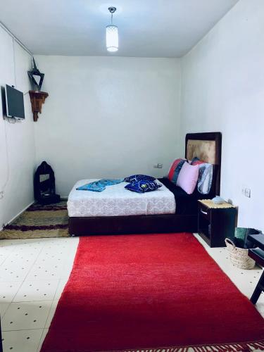 a bedroom with a bed and a red rug at Calm appartment close to airport of Marrakech in Marrakech