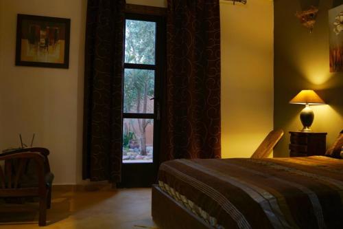 a bedroom with a bed and a large window at Villa Zazate in Ouarzazate
