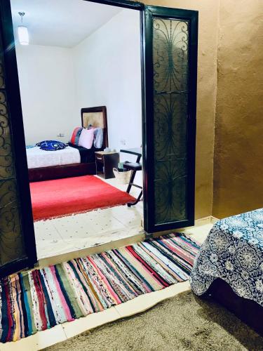 a mirror in a room with a bed and a rug at Calm appartment close to airport of Marrakech in Marrakech