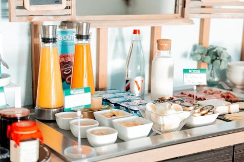a buffet of food and drinks on a counter at Brit Hotel Confort Saint-Lô in Saint Lo