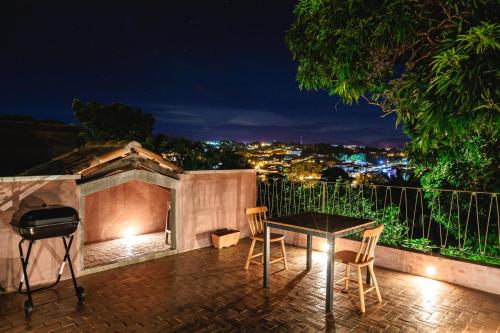 a table and chairs on a patio at night at Incrível Casa Colonial-Déco - Centro Histórico in Marechal Floriano