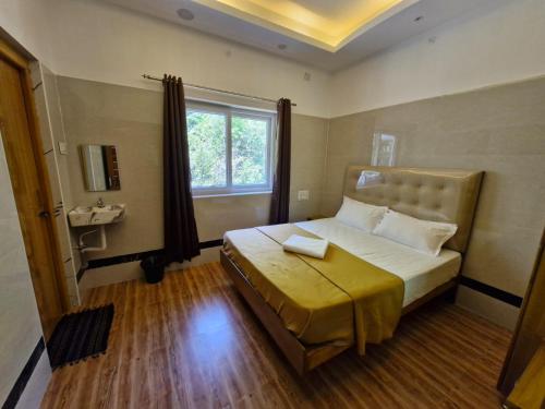 a bedroom with a bed with a sink and a window at Saraa Grand in Kuttālam