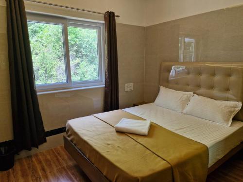 a bedroom with a large bed with a large window at Saraa Grand in Kuttālam