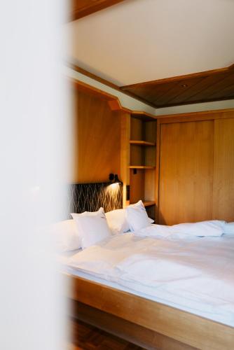 a bedroom with a large bed with a wooden headboard at Pension Rudolph in Gaschurn