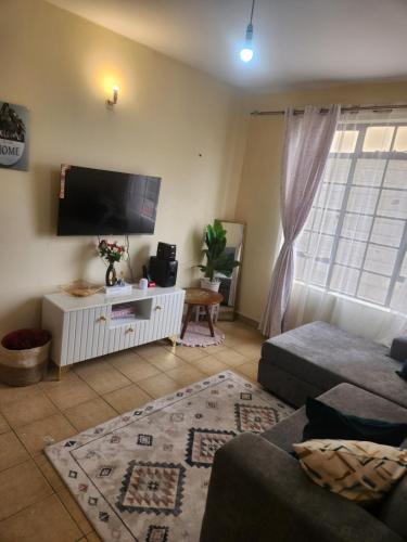 a living room with a flat screen tv and a couch at Cozzyville in Machakos