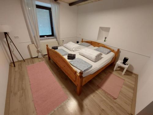 ein Schlafzimmer mit einem Holzbett und einem Fenster in der Unterkunft Casa Georgio Vendégház in Szentgyörgyvár