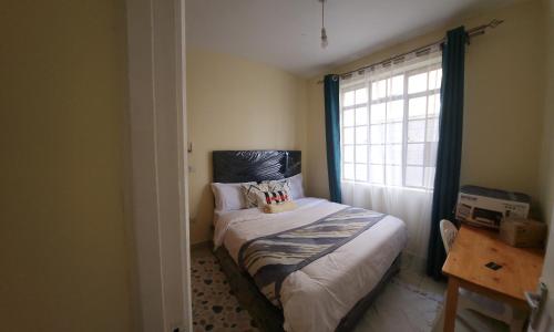 a small bedroom with a bed and a window at Cozzyville in Machakos