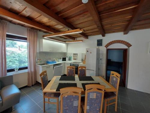 eine Küche mit Tisch und Stühlen und einem Kühlschrank in der Unterkunft Casa Georgio Vendégház in Szentgyörgyvár