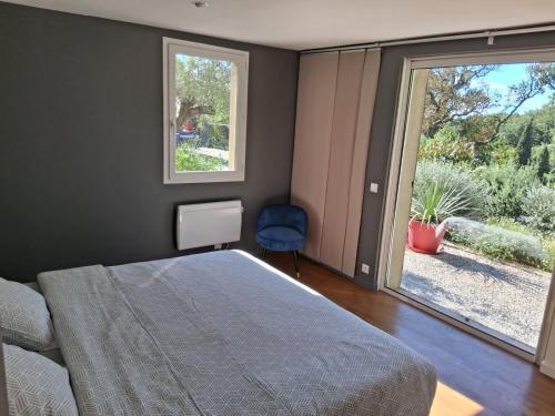une chambre avec un lit et une grande fenêtre dans l'établissement Rez de Jardin d'une Bastide VILLA LA GARDI avec Piscine privée, à La Garde-Freinet