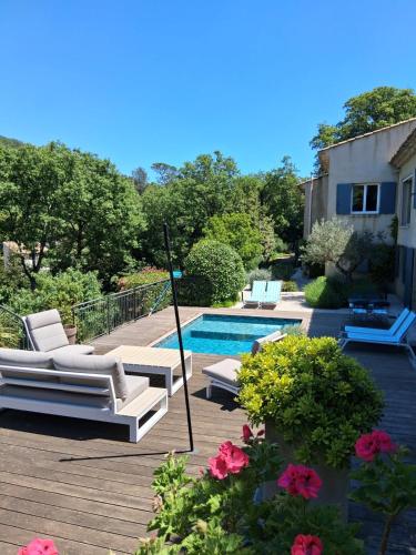 une terrasse avec des chaises et une piscine dans l'établissement Rez de Jardin d'une Bastide VILLA LA GARDI avec Piscine privée, à La Garde-Freinet