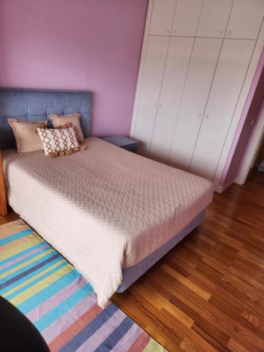 a bedroom with a bed with a purple wall at Beach Apartment Furadouro in Ovar