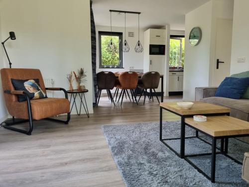 a living room with a couch and a table at Vrijstaande woning met jacuzzi in grote tuin in Ewijk