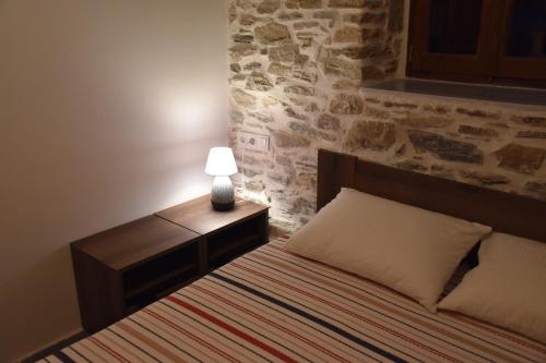 a bedroom with a bed with a lamp on it at Dendrokipos in Mouresi