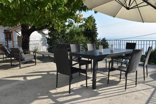 a black dining table and chairs with an umbrella at Dendrokipos in Mouresi