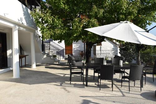 a table and chairs with a white umbrella at Dendrokipos in Mouresi