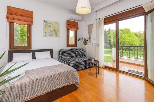 a bedroom with a bed and a balcony at Suite Acropolis Serres With Parking Next to Center in Serres