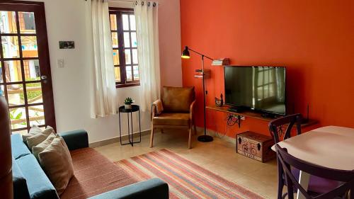 a living room with a flat screen tv and a couch at Apartamento Chapada Diamantina in Lençóis