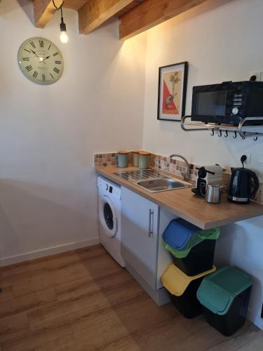 a kitchen with a sink and a washing machine at Le Petit Gite du Roy in Courlay