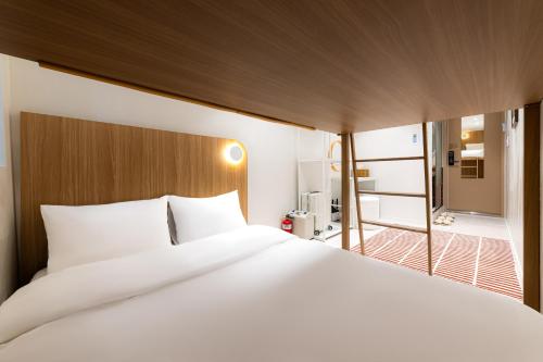 Ένα ή περισσότερα κρεβάτια σε δωμάτιο στο Slowon Hostel 슬로우온 호스텔 홍대