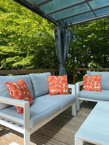 un canapé assis sous un parasol sur une terrasse dans l'établissement Les bord du Lac Leman, à Sciez