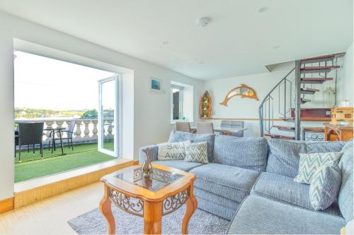 a living room with a blue couch and a table at Glandore Cliff Cottage Getaway - Sea Access with Private Pier in Glandore