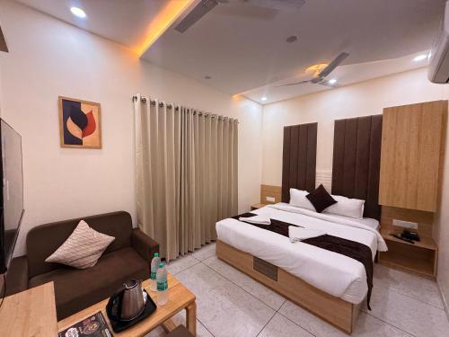 a hotel room with a bed and a couch at Hotel Kusum Kunj in Ujjain