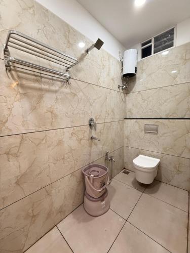 a bathroom with a toilet and a wall at Hotel Kusum Kunj in Ujjain