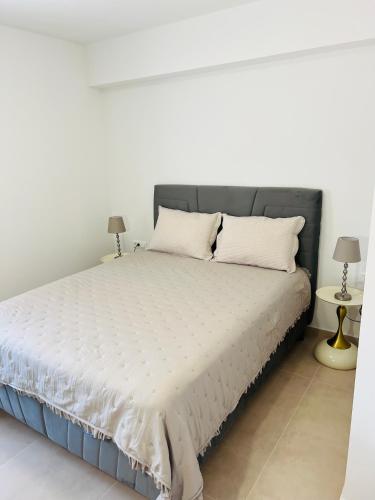 a bedroom with a large white bed with two lamps at Apartmani Leon in Međugorje