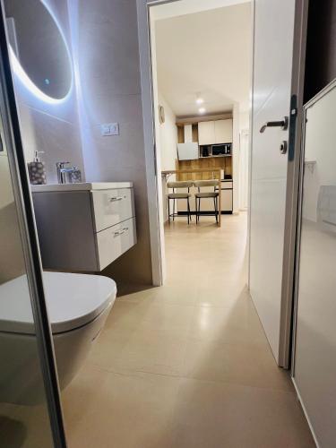 a bathroom with a toilet and a kitchen at Apartmani Leon in Međugorje