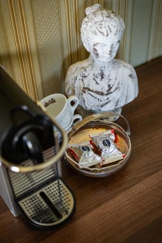 a statue sitting on a table next to a cup at Penzion Na Červeném Potoce in Králíky
