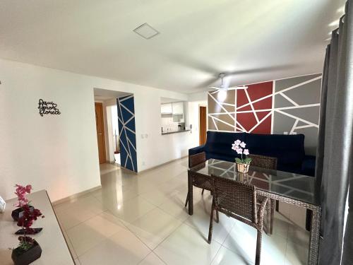 a living room with a table and a blue couch at Prainha - Apartamento 3 Quartos in Arraial do Cabo
