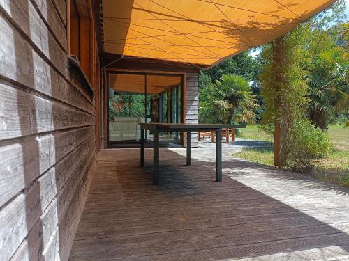 a picnic table on a porch of a house at Gîte de la Croix Regnault in Raids