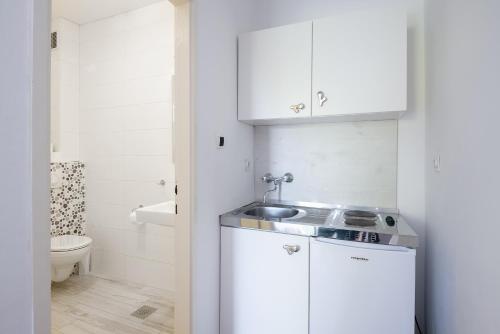 a small white kitchen with a sink and a toilet at Guest House Villa Bellevue 1 in Cavtat