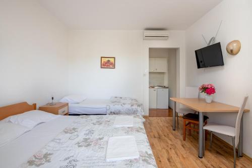 a bedroom with a bed and a table and a desk at Guest House Villa Bellevue 1 in Cavtat