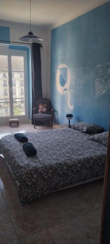 une chambre avec un lit et un mur bleu dans l'établissement Chez Brigitte Guesthouse, à Nice