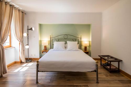 a bedroom with a large bed with white sheets at Château De La Caze Piscine & Spa - Ste Enimie in Sainte-Énimie