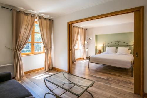 a bedroom with a bed and a glass table at Château De La Caze Piscine & Spa - Ste Enimie in Sainte-Énimie