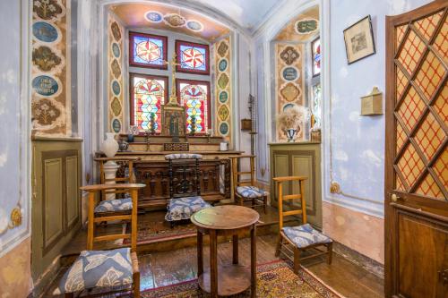a room with a table and chairs and a stained glass window at Château De La Caze Piscine & Spa - Ste Enimie in Sainte-Énimie