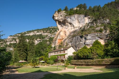 a large house in front of a mountain at Château De La Caze Piscine & Spa - Ste Enimie in Sainte-Énimie