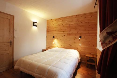 - une chambre avec un lit blanc dans un mur en bois dans l'établissement Les Cabasses 6 - Accommodation in a village house, à Villar-dʼArêne