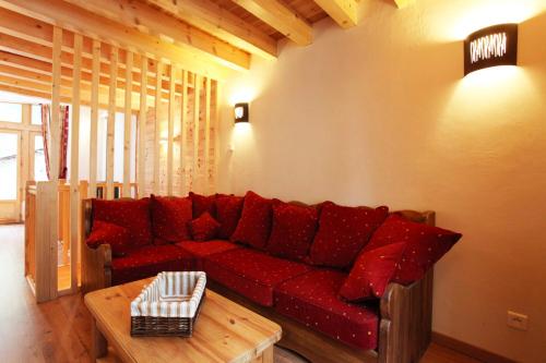 un salon avec un canapé rouge et une table dans l'établissement Les Cabasses 6 - Accommodation in a village house, à Villar-dʼArêne
