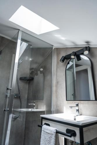 a bathroom with a sink and a shower with a mirror at Apartamentos Turísticos El Puerto de Comillas in Comillas
