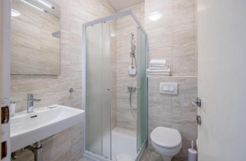 a bathroom with a shower and a toilet and a sink at Guest House Villa Bellevue in Cavtat