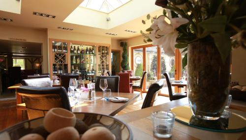 a dining room with a table and a vase with flowers at The Black Horse at Ireland in Shefford