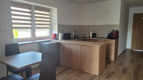 a kitchen with wooden cabinets and a table and a table and chairs at Wiślana 4 in Spytkowice