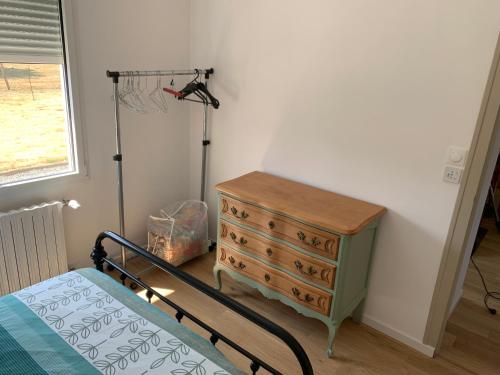 a bedroom with a bed and a dresser and a window at Ty Bihan Breizh in Pénestin