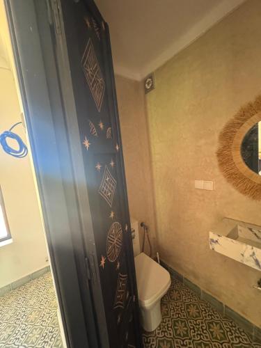 a bathroom with a toilet and a shower door at Ecolodge Dar bouhouta in Tahannout